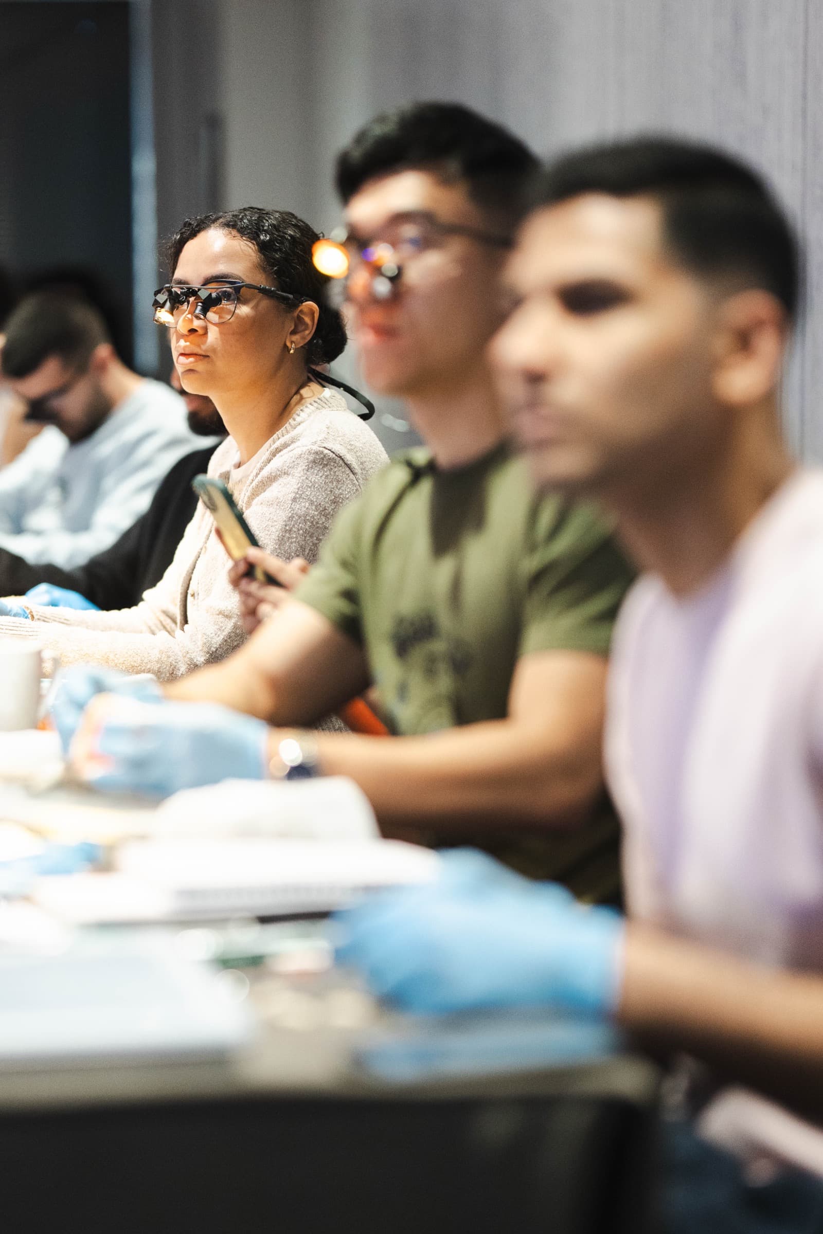 Delegates wearing loupes watching a demonstration on a Simplifi course